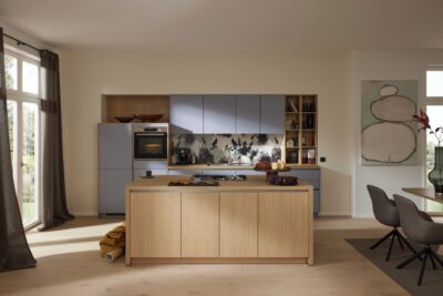 Helles Blau trifft auf helles Holz und verströmt eine nordische Attitüde. Unterstrichen wird das zusätzlich von den klaren, reduzierten Formen. Es ist eine Kombi aus den Küchen „Sunta“ und „Stadum“ in Eiche Como Nachbildung von Mondo