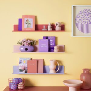 Der Schrank und die schwebenden Regale haben Flair. Die Kombi der Töne hat eine insgesamt sonnige Anmutung und noch dazu sehr zeitgemäß. Schön ist es, dass auch die Accessoires, Bücher und Bilder die gleiche Farbwelt haben. Die Möbel sind aus pulverbeschichtetem Stahl von Mustard Made.