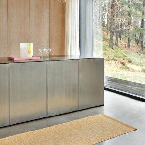 So hübsche ist der schlichte Inselblock mit Edelstahlfronten und Arbeitsfläche. Durch das Holz und die lieblichen Deko-Elemente wird der Look regelrecht gemütlich. Dazu trägt auch der Teppich „Sam“ im Farbton „Mustard“ von Pappelina bei.