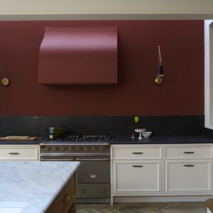 Eine tolle Idee ist es, eine Wand in einem herbstlichen Farbton zu streichen. Farrow & Ball hält da sehr schöne Nuancen bereit. Hier wurde ebenfalls die Haube und auch Fronten im gleichen Ton gewählt. Das macht den Raum besonders. Der Rotton heißt „Etruscan Red“.