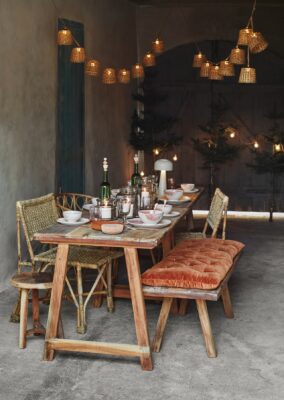 Im etwas geschützten Bereichen, zum Beispiel in einer Garage, kann ein winterliches Dinner stattfinden. Hübsch sind dafür Materialine wie Samt, Holz und Rattan und viele Lichter. Alles von Madam Stoltz. Tipp: Legen Sie Wolldecken bereit, damit keiner friert.