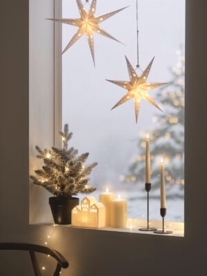Ein stilles Fensterbild wie aus einem nordischen Wintermärchen. Dafür sorgt der kleine, verschneite Tannenbaum, die weißen, beleuchteten Häuser und die LED-Kerzen. Fügen Sie noch einen Hauch Sternenglanz dazu und schon erschafft man sofortige Weihnachtsstimmung. Alle Beleuchtungen sind von Lights4fun.