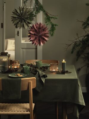 Ganz in Grün zeigt sich der Tisch mit natürlicher Anmutung. Toll dazu sind die natürlichen Zweige im Skandi-Stil. Dunkles Rot und mattes Gold harmonieren perfekt zum Grün. Alles ist von JYSK.