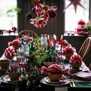 Eine fröhlich verspielte Weihnachtstafel in kräftigen Rot- und Grüntönen harmoniert gekonnt mit üppigem Tannengrün und den tollen Papier-Bonbons. Alles wirkt lebendig, bunt und einladend und sorgt für pure Festtagslaune, von Ikea.