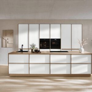 Die Designlinie „Sakura“ bringt den Japandi-Stil in jede Küche. Charakteristisch sind eine präzise Linienführung, das reduzierte Design und einzelne Elemente in Holzoptik. Vorgezogene Wangen ergeben die typische Rahmenanmutung. Erhältlich über Küche & Co.