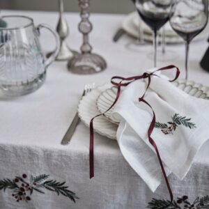 Niedlich auf dem gedeckten Tisch sind bestickte Servietten, zum Beispiel mit kleinen Zweigen oder Beeren. Sie unterstreicht eine natürliche Deko oder passt als Stilbruch zu eleganten Settings. Alles von Lene Bjerre.