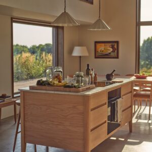 Weich geschwungene Kücheninsel mit heller Steinplatte werden zu einem Design mit Wohlfühlcharakter. Küche „Borough“ ist eine Neuinterpretation einer ländlichen Küche von Neptune. Alle Stücke können einzeln als Modul verwendet werden oder lassen sich zu einer kompletten Küche zusammenstellen. Das Modell vereint Einflüsse des skandinavischen Mid-Century-Designs mit britischem Stilgefühl. Hergestellt ist alles aus massiver Eiche und Tulipwood. Die klaren Linien werden durch abgerundete Ecken sanft gebrochen. Das verleiht der Kollektion eine moderne Leichtigkeit.