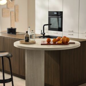 Super elegant kommt das neue Dekor „Walnuss Havanna“ daher. Es gehört zur Serie „Manhattan“ von Nolte Küche. Genau wie der Frontenton „Kaschmir softmatt“. Toll dazu ist der runde Ansatztisch, der dem Design die Strenge nimmt. Noch dazu ist er sehr praktisch. So ein Tisch kann die Lösung sein, wenn Sie Ihre Küche durch weiche Formen ergänzen wollen.
