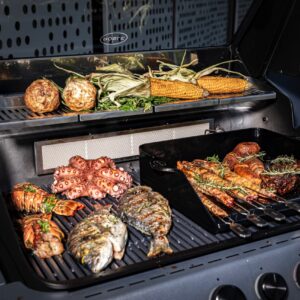 Mit dem Grill Gasgrill „Blazeflame“ hat Hersteller Rösle ein modernes Design mit cleveren Funktionen geschaffen. Hier funktioniert alles unkompliziert, von der einfachen Reinigung bis zur perfekten Hitzeverteilung. So lassen sich saftige Steaks, zartes Gemüse oder knusprige Drehspießgerichte leicht zubereiten. Die nahtlose Brennkammer aus Aluminium-Druckguss sorgt für maximale Hitzeeffizienz und Langlebigkeit. Hilfreich sind auch der Seitenbrenner oder die Warmhalteroste.