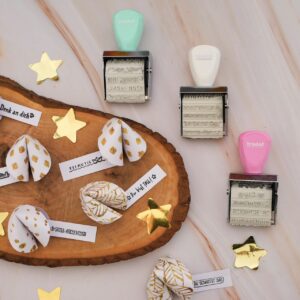 Eine süße Idee ist es, Glückskekse aus Papier zu falten. Darin steckt ein motivierender Spruch fürs Neue Jahr. Tipp: Hübsch sieht es aus, den Spruch zu stempeln. Tolle Stempel mit unterschiedlichen Schriften gibt es von Trodat. 