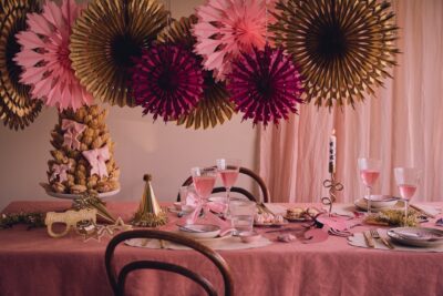 Romantisch verspielt wird der gedeckte Tisch mit Rosatönen. Als Drink passt ein Rosé-Sekt oder Crémant dazu. Veredelt wird die Gestaltung von Golddetails. Ein Hingucker sind die hängenden Rosetten. Alles von Søstrene Grene.