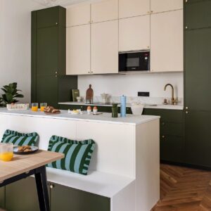 Diese Bank steht nicht einfach nur an der Küchenzeile, sie ist komplett integriert. Auf diese Art und Weise ist ein gemütlicher und attraktiver Raumteiler entstanden. Mit matten Fronten von Plum Living.