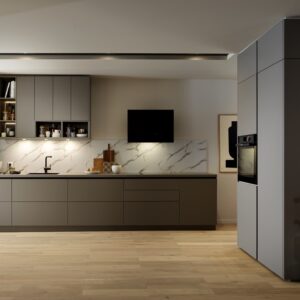 Die Küchenausstattung in grauem „Claystone“ geht quasi nahtlos in den Wohnbereich über mit dem Solitär, der dekorativ in der Mitte des Raumes platziert wurde. Er ist von allen Seiten zugänglich und so ein multifunktionales Element. Von Schmidt Küchen.