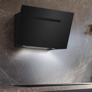Für einen Wow-Effekt sorgt die „studioLine Designesse“ von Siemens. Ihre matte Oberfläche absorbiert das Licht, statt es zu reflektieren. Das sieht schick aus. Der schräggestellte Schirm neigt sich so zur Wand, dass er die Blickachse zum Koch-feld freihält. Die Haube saugt Gerüche, Fett und Dampf mit „iQDrive“ ab, einem starken Motor.