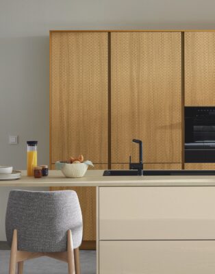 Eher Beige als Greige präsentiert sich die Zeile von Ballerina Küchen. Ergänzt wird sie durch die Fronten in Wiener Geflecht. Das ergibt einen außergewöhnlichen Stil. Pur trifft dabei auf verspielt. Die Wand in Greige ist optisch die perfekte Mitte zwischen den beiden Looks.