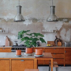 Die grobe Struktur von Wand und Boden fällt gleich ins Auge. Die Küche besteht aus einzelnen Elementen und kombiniert Industrial-Chic mit Landhausflair. Pflanzen machen den Raum lieblich, sie stecken in hochwertigen Tontöpfen von Bergs Potter.