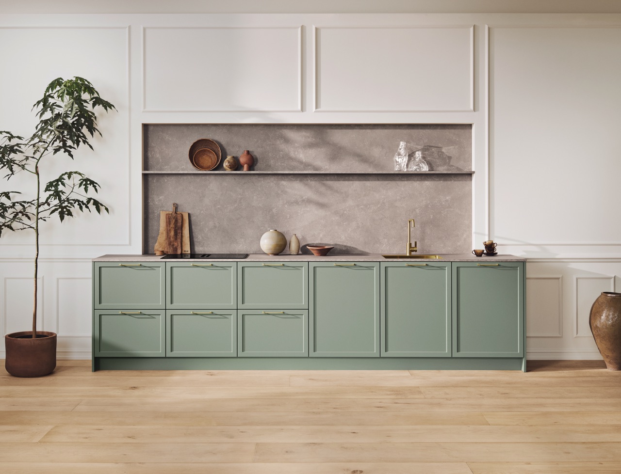 Kassetten an Fronten und an der Wand verleihen dem Raum Tiefe. Dazu kommt die Rückwand in Stein-Optik. Materialien mit sichtbarer Struktur spielen im jetzigen Landhausstil eine zentrale Rolle, weil sie Natürlichkeit vermitteln. Aus der Serie „Celleno“ in angesagtem Salbeigrün von Kvik.