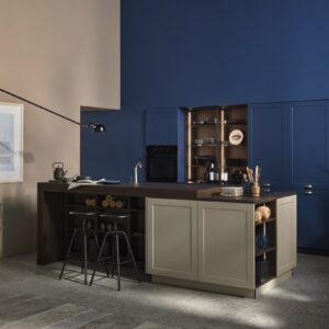 Fast ein bisschen Retro sieht die Gesamterscheinung der Küche aus. Verschiedene Möbelstile werden gemixt, Kühle trifft auf Wärme, Schlichtheit auf Knallfarbe. Absolut gekonnt! Vor allem das ineinander übergehen von Wand und Küchenfronten verdient einen zweiten Blick. Alles von Nolte aus der Linie „Ravenna“ in „Blaubeere“ und „Greige“, beide Töne in „Softmatt“.