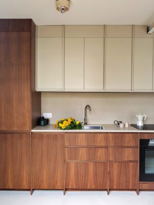 Bei der Küche von Plum Living spielt Greige eher eine untergeordnete Rolle und das Wallnussbraun dominiert. Das Gute ist, dass dadurch das Holz leichter, frischer und moderner aussieht. Richtig schön zeigt sich auch die Form der Fronten, die in beiden Optiken einheitlich ist.