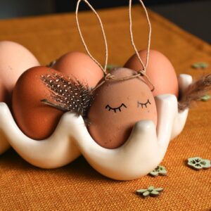 Zurückhaltend, aber richtig ansprechend kommen die Eier in der Schale daher. Sie werden mit ein paar einfachen Handgriffen in Hasen verwandelt. Die Eier-Häschen sind eine entzückende Idee, auch für gekochte Eier. Zuerst mit einem lebensmittelechten Stift ein Gesicht auf das Ei malen. So bekommt jedes Ei eine eigene Mimik. Für die Ohren bietet sich ein Draht an, zum Beispiel ein Papierdraht, denn er bleibt in Form. Einfach formen und aufsetzen. Idee von Rayher.