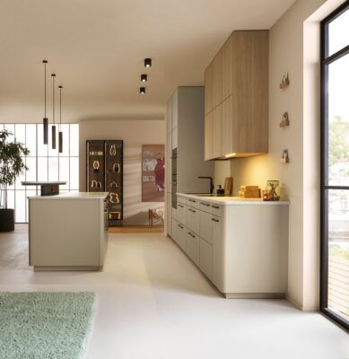 Ein wenig asiatisch anmutend nimmt man die Küche von Schüller wahr. Sie begeistert auch mit ihren Rundungen und der schmalen Optik. Alles ist sehr hell gehalten, was schon beim Anblick gute Laune verbreitet. Die Frontfarbe heißt „Salona Sandgrau matt“.