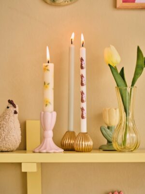Ein Mix aus verschiedenen Kerzen und Kerzenständern wirkt lässig. Süß sehen die Accessoires auf einem Küchenregal aus. Dazu können Blumen oder ein Huhn kombiniert werden. Sie passen aber auch perfekt auf den Ostertisch. Alles von Søstrene Grene.