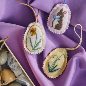 Wie selbstgemacht sehen die weißen Anhänger aus Stoff aus. Sie veredeln filigrane Zweige mit ihren liebevollen Motiven. Eine Besonderheit der Stoffeier sind die gezackten Kanten, von Søstrene Grene.