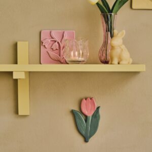 Die Tulpe ist ein Begleiter für viele Jahre, zumindest die rosa Tulpe an der Wand. Sie kann zu Ostern aufgehangen werden und den Frühling über ihren Platz behalten. Ein Blickfang ist ebenfalls die Kachel mit Schneeglöckchen-Motiv auf dem Regal. Alles von Søstrene Grene.