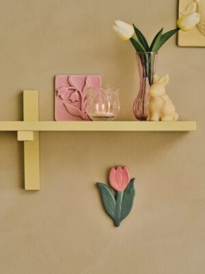 Die Tulpe ist ein Begleiter für viele Jahre, zumindest die rosa Tulpe an der Wand. Sie kann zu Ostern aufgehangen werden und den Frühling über ihren Platz behalten. Ein Blickfang ist ebenfalls die Kachel mit Schneeglöckchen-Motiv auf dem Regal. Alles von Søstrene Grene.