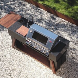 Die modulare Küche „BBQube Classic“ von OQC setzt ein echtes Statement im Garten. Sie vereint Gasgrill, Spüle und eine großzügige Arbeitsflächen. Eingefasst wird sie von einer robusten Verkleidung aus Stein und Holz.