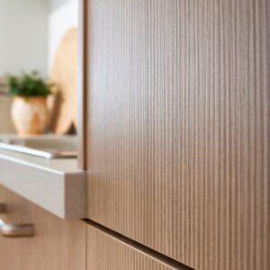 Die helle holzfarbene Küche wirkt modern. Gefertigt ist sie aus einem Holzwerkstoff mit einer ausgefallenen, nicht sehr tiefen Rillenoptik. Die ideale Küche für alle, die es praktisch, aber stylish haben wollen, von Global Küchen.