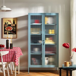Der Metallschrank „The Collector“ von Mustard Made beweist, wie unkompliziert sich zartes Blau auch als einzelnes Möbelstück in die Küche integrieren lässt. Der Farbton „Ocean“ zeigt sich leicht nostalgisch. Die Nostalgie wird noch unterstützt von verspielten Farbakzenten wie dem roten Tischtuch. Insgesamt wirkt die alles warm, vor allem durch den Holzboden.