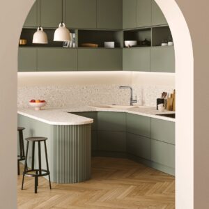 Mit Rundungen zu arbeiten ist ein großer Trend für die Küche. Insgesamt bekommt dadurch alles einen weicheren Charme. Im doppelten Sinne wird der Trend bei Villeroy & Boch aufgegriffen. Denn die Insel ist rund und ihre Rillenhölzer ebenfalls. Auch die Eckspüle ist fast organisch geformt. Das i-Tüpfelchen bildet der Eingangs-Bogen.