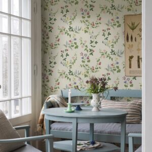 Die Tapete „Midsummer Eve“ von Boråstapeter bringt romantische florale Muster und sanfte Blautöne zusammen. In Kombination mit den hellblauen Esszimmer-Möbeln entsteht eine Atmosphäre im klassischen Skandi-Stil. Charmant präsentiert sich die Verbindung aus zarter Farbigkeit und nostalgischen Details, ohne dabei überladen zu erscheinen.