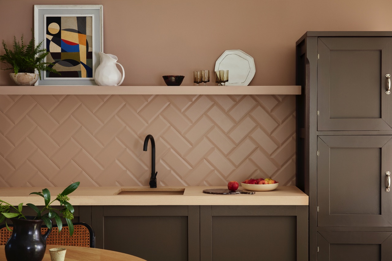 Fischgrätmuster kennt man eigentlich von Parkettböden. Übertragen auf Wandfliesen sieht es überraschend stylish aus und gibt der Küchenrückwand eine architektonische Struktur. Verstärkt wird das durch das zarte Rosa, welches sich auch über die Wand zieht und sogar für das Regalbrett verwendet wurde. Monochrom wirkt es, dass auch die Fugen im gleichen Farbton daherkommen. Wandfarbe „Mochi“ von Little Greene.