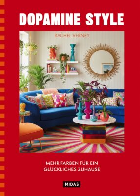 In Dopamine Style erklärt Innenarchitektin Rachel Verney, wie sich mit kräftigen Farben, markanten Mustern und unterschiedlichen Materialien individuelle Wohnwelten gestalten lassen, die Freude bereiten. Neben den Grundlagen der Farbgestaltung finden sich zahlreiche Einrichtungsideen, praktische DIY-Projekte und inspirierende Beispiele für jeden Raum. Die opulenten Fotografien machen das Buch zu einer ebenso informativen wie dekorativen Inspirationsquelle für alle, die ihrem Zuhause mehr Buntheit verleihen möchten. Erschienen im Midas Verlag, 24 Euro.'Dopamine Style' showing a bright, colorfully styled living room with a blue sofa, multicolored cushions, plants, and a round sunburst mirror; author Rachel Verney listed above the scene; German subtitle text and MIDAS logo at bottom.”]}}``` (Note: If you prefer shorter options: